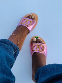 the feet of a woman wearing pink and gold sandals